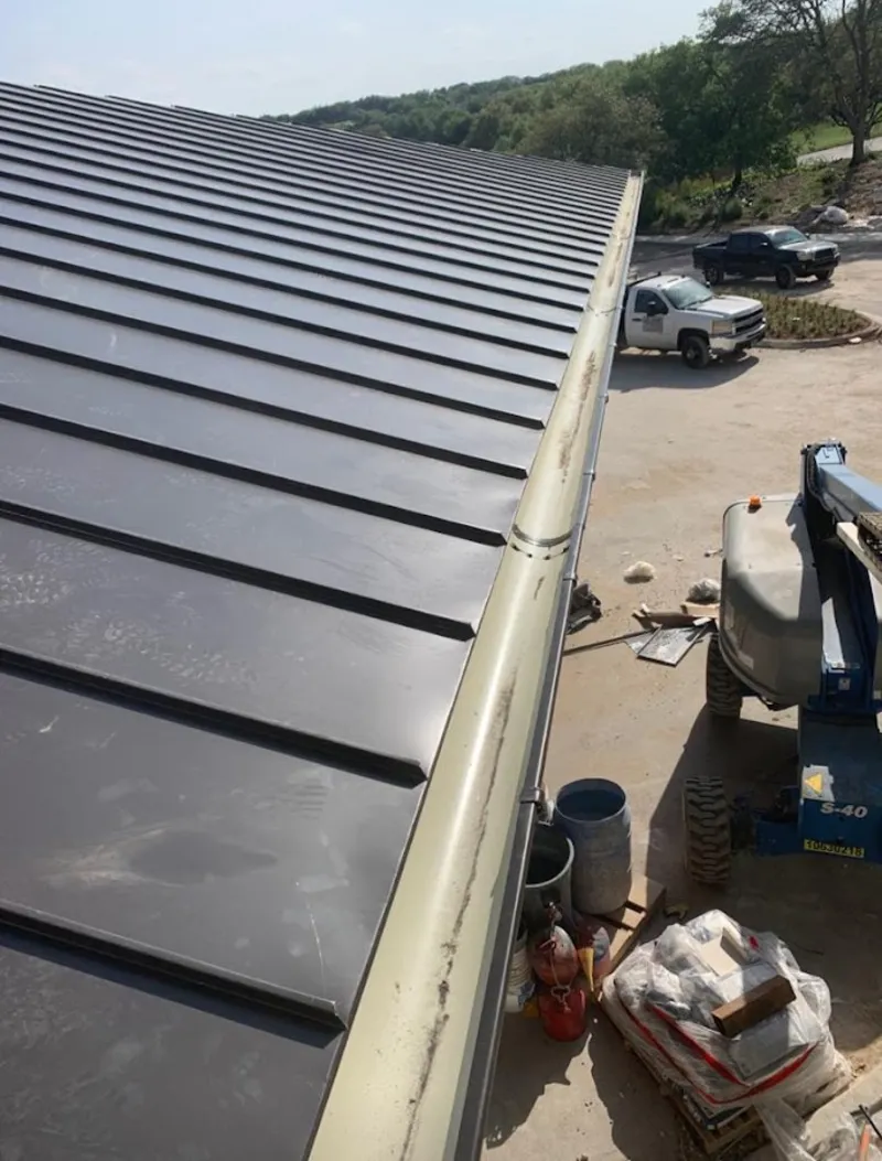 Standing seam panel and gutter detail on a metal roofing jobsite in Fort Rucker